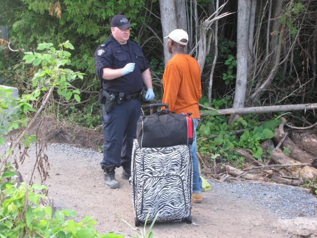 Canadian police officer arrests a Haitian asylum-seeker